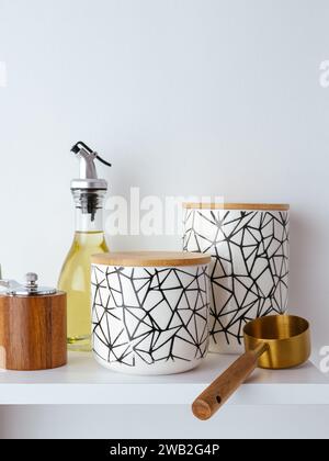 There is olive oil and storage containers on the kitchen shelf Stock Photo