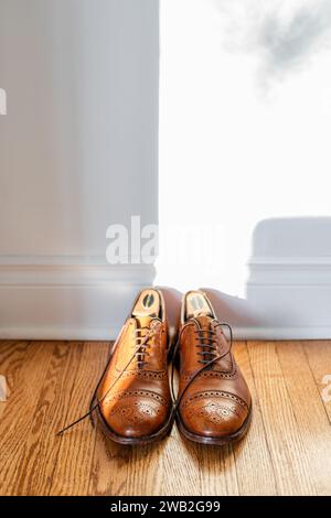 Men's brown leather dress shoes on the hardwood floor Stock Photo