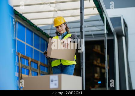 Warehouse receiver standing inside of truck in cargo area, trailer, barcode scanning delivered items. Receiving clerk holding scanner checking Stock Photo