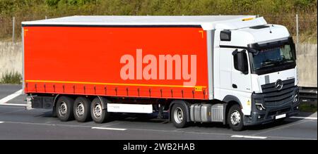 Wielton Group tautliner semi trailer with roll back roof cover towed by Mercedes Actros L lorry truck power unit rig prime mover driving M25 UK road Stock Photo