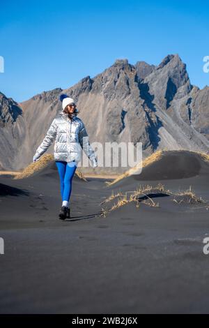A young Caucasian woman posing on the beach with black sand Stock Photo
