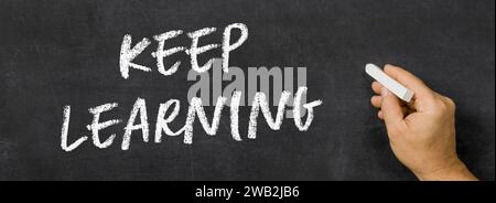 Text written on a blackboard -  Keep learning Stock Photo