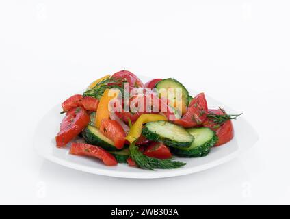 Salad of freshly chopped tomatoes, cucumbers and sweet peppers with dill, drizzled with oil on a white background Stock Photo