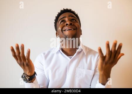 Portrait of young businessman who is disappointed and anxious. He is praying. Stock Photo