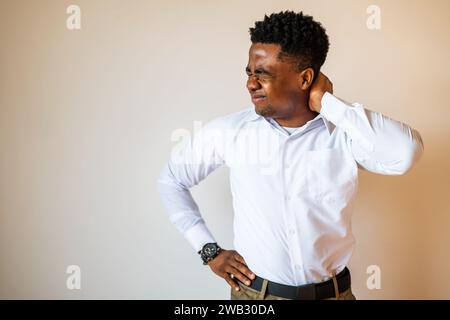 Portrait of young businessman who is having pain in his neck. Copy space on image for your text or advert. Stock Photo