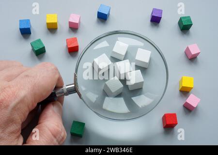 Ethnocentrism concept. White cubes and magnifying glass. Stock Photo