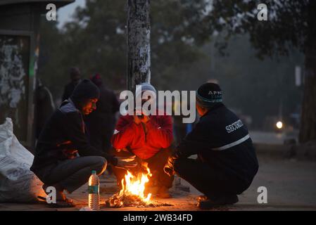 NEW DELHI, INDIA - JANUARY 7: People warm-up around a bonfire on a cold winter morning at South West Delhi, Kapashera bus stand near MCD Office, on January 7, 2024 in New Delhi, India. Foggy morning challenges Delhi-NCR with intensifying cold wave, mercury dips further across North India. (Photo by Parveen Kumar/Hindustan Times/Sipa USA ) Credit: Sipa USA/Alamy Live News Stock Photo