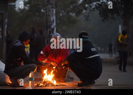 NEW DELHI, INDIA - JANUARY 7: People warm-up around a bonfire on a cold winter morning at South West Delhi, Kapashera bus stand near MCD Office, on January 7, 2024 in New Delhi, India. Foggy morning challenges Delhi-NCR with intensifying cold wave, mercury dips further across North India. (Photo by Parveen Kumar/Hindustan Times/Sipa USA ) Credit: Sipa USA/Alamy Live News Stock Photo