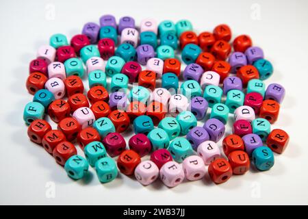An array of colorful cubic beads with letters on a white background Stock Photo