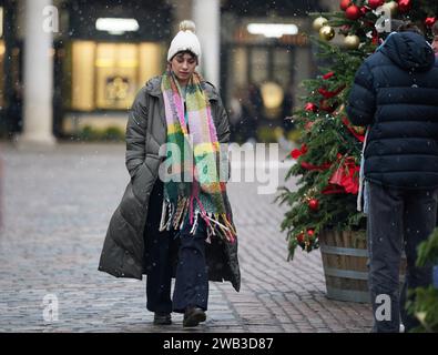 A person walks through Covent Garden in London. Sleet and snow showers have been forecast for parts of the country on Monday as some regions are still trying to grapple with flooding following intense rainfall. Picture date: Monday January 8, 2024. Stock Photo