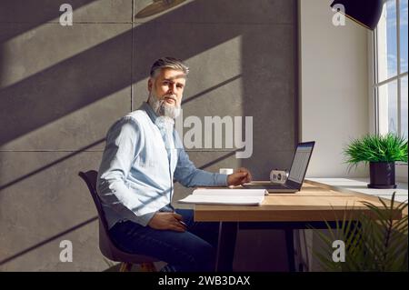 Businessman working with laptop and paper documents at home office Stock Photo