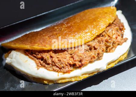 Venezuelan Cachapa with Pulled Meat on Black Plate in Restaurant Stock Photo