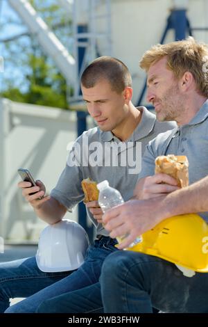 two workers taking break while having their lunch Stock Photo