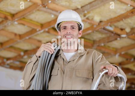 happy male builder doing electrical repairs Stock Photo