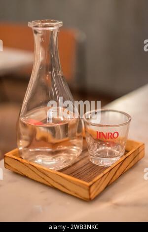 London, United Kingdom - 16 November 2017: Jinro Chamisul Soju bottle with glass. It is a famous clear, colorless distilled beverage of Korean origin. Stock Photo