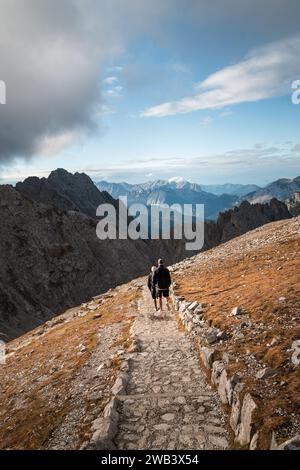 Landscape of two hikers walking down the mountain after hiking up. Stock Photo