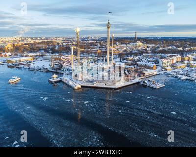 Panoramic view of the amusement park of Grona Lund in Stockholm, Sweden in winter, with snow and ice on the sea. Bright morning light. Stock Photo