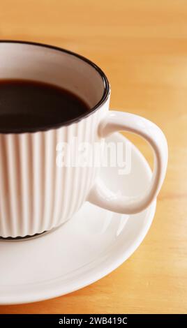 Cup of black coffee isolated on wooden table Stock Photo