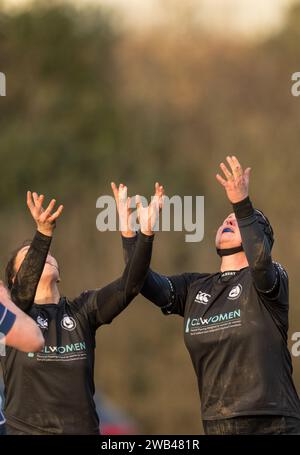 Female amateur rugby union players arms out to catch the rugby football. Stock Photo