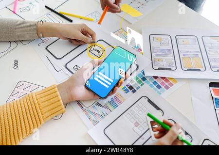 Process of creating an interface for a mobile app. User interface and experience concept. Modern app on smart phone in woman hands Stock Photo