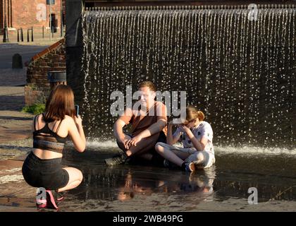 Teenagers having fun taking photos and getting wet in a fountain by the Amber Museum in Gdansk, Poland, Europe, EU Stock Photo