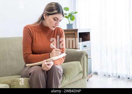 Young Latina psychologist taking notes in a notebook during a therapy Stock Photo