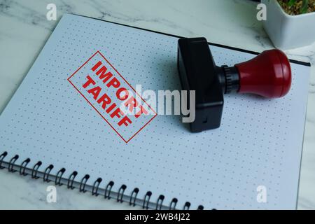 Red Handle Rubber Stamper and Import Tariff text isolated on wooden background Stock Photo