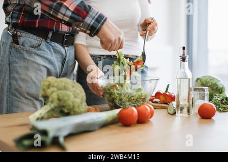 Caucasian old couple spends free time cooking breakfast in modern light kitchen. Stock Photo
