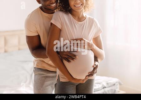 Cropped Shot Of Young African American Expectant Couple Embracing Indoor Stock Photo