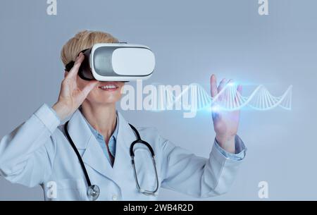 Professional woman doctor in VR glasses studying blue glowing virtual human DNA strand, using futuristic CRISPR method Stock Photo