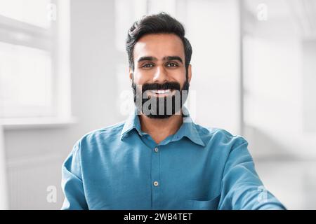Confident businessman in blue shirt, headshot with smile Stock Photo