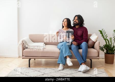 Excited young man and woman using digital tablet at home Stock Photo