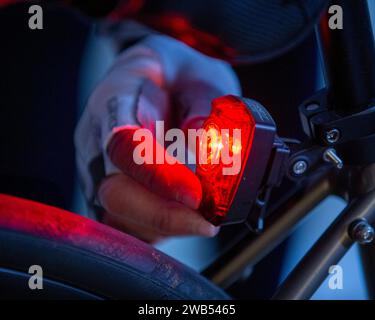 Woman turning on the rear light on her bicycle Stock Photo