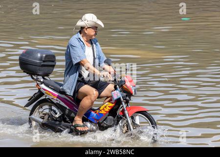 SAMUT PRAKAN, THAILAND, NOV 18 2023, A motorbike rides on a flooded street Stock Photo