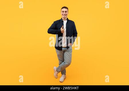 Positive young european man showing thumb up and smiling Stock Photo