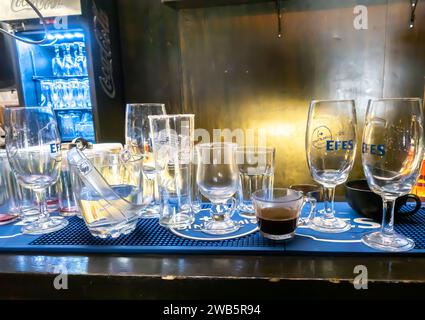 dirty glasses of various sizes and for different types of drink on a bar desk Stock Photo