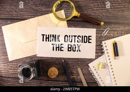 Concept image about unconventional or different thinking. Think outside the box handwritten with white chalk on blackboard. Stock Photo