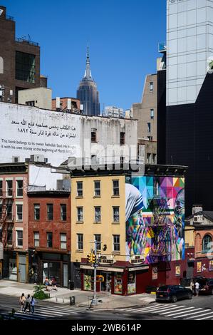 Large mural of Mother Teresa of Calcutta painted on the side wall of an old building in New York with the Empire State Building in the background Stock Photo
