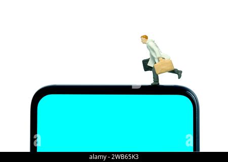 Miniature people toy figure photography. A businessman wearing coat running above blue screen smartphone. Isolated on white background. Image photo Stock Photo