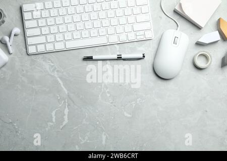 Flat lay composition with wired computer mouse and keyboard on light grey marble table. Space for text Stock Photo