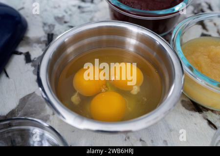 Three eggs in dish surrounded by other ingredients. Stock Photo