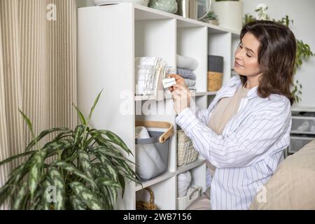 Woman hands organizing cotton pillowcase storage in basket with sticker tag mark at closet shelf Stock Photo