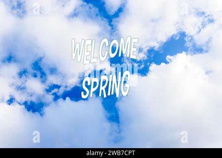 Welcome Spring text on blue sky background. Spring equinox concept. Stock Photo