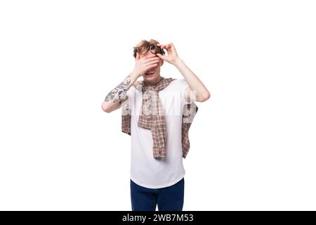 young European red-haired guy rubs his eyes after wearing glasses Stock Photo
