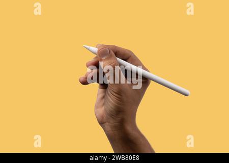 Black male hand holding an smart pencil isolated on yellow. Stock Photo