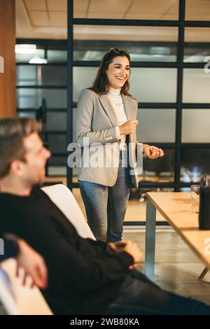Happy group of professionals in a vibrant office engage in creative brainstorming, discussing project management and the Scrum process. Led by an insp Stock Photo