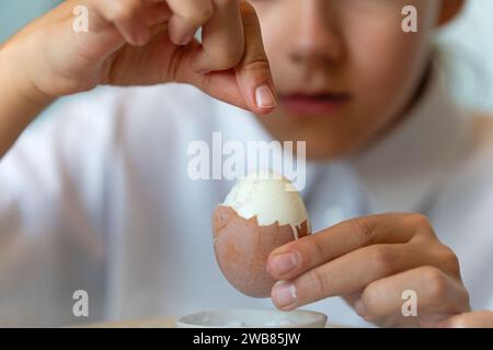 the girl solid boiled egg. Close-up. Stock Photo