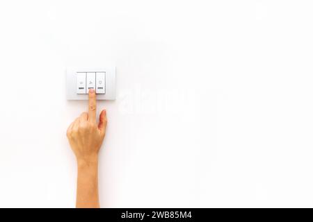 Switch on and switch off light. Control of electricity consumption at home banner. Female finger on light switch. Stock Photo