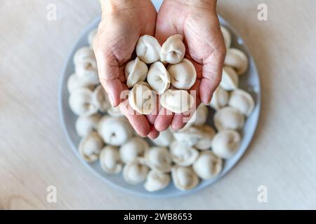 hands make dumplings, hands kneading dough, baker, Baker's hands, dough, hands in the flour, dumplings, handmade dumplings, ravioli view from above , Stock Photo