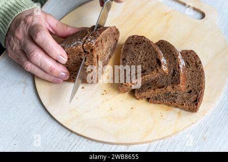 Fresh bread slice and cutting knife on table in the kitchen. top view rye bread, Stock Photo